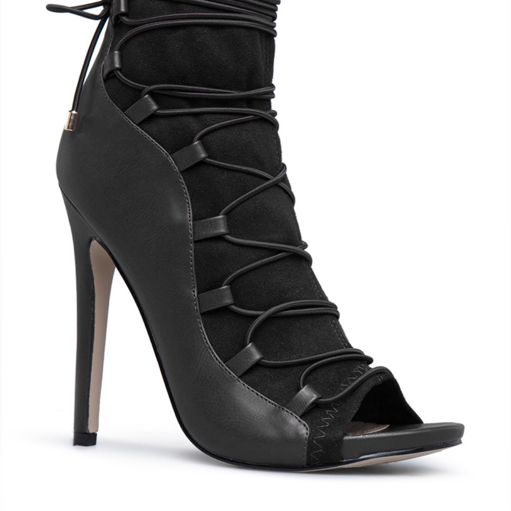 A stretch to fit stiletto ankle bootie with wrap around laces and black zipper.